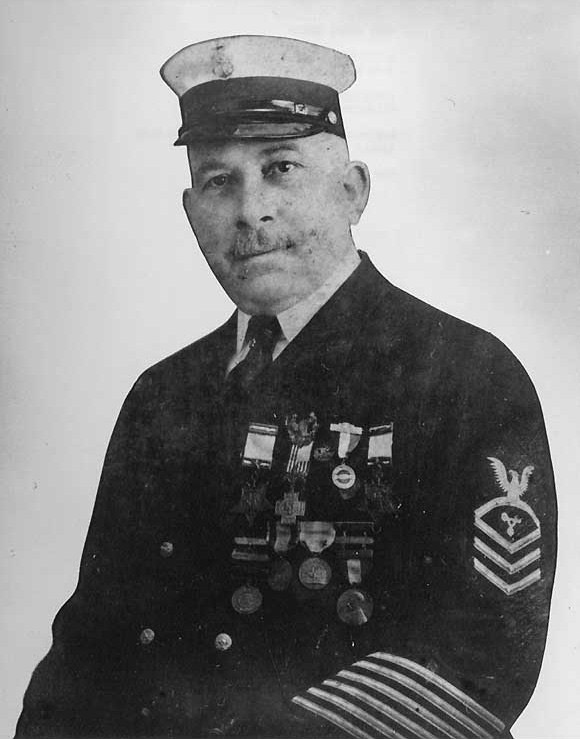 White man with mustache in Naval uniform with medals and cap
