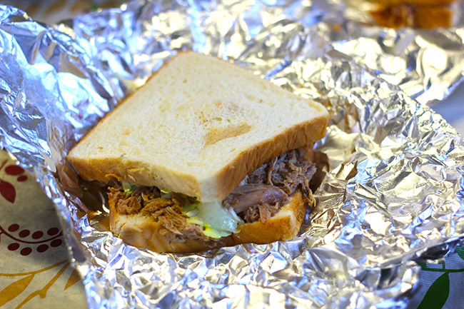 Barbecued pork on white bread in aluminum foil