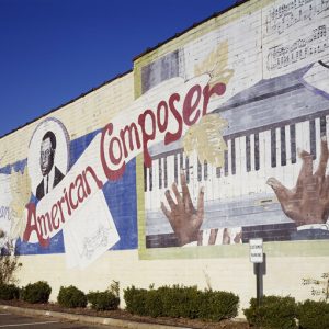 "Scott Joplin American Composer" painted mural on brick building showing black hands on piano keys