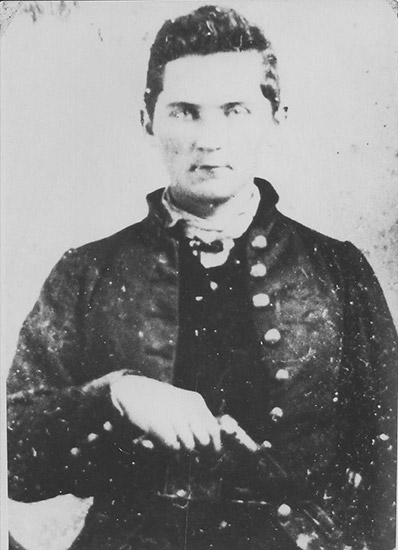 White man in military uniform holding revolver
