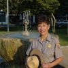 Hispanic woman in park ranger uniform smiling at fountain
