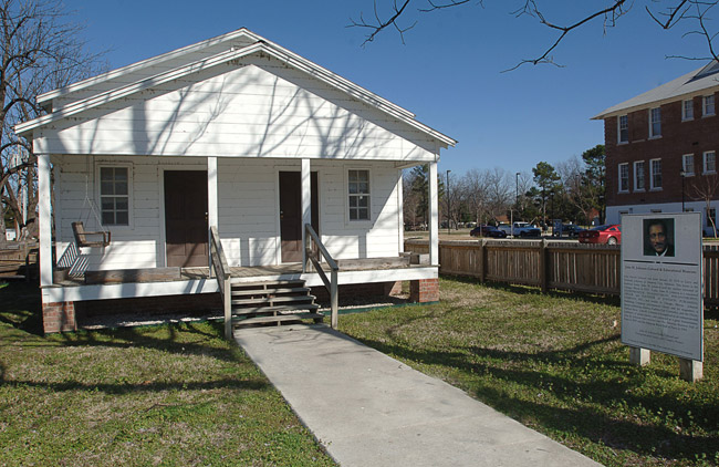 White wooden house with two front doors and porch swing