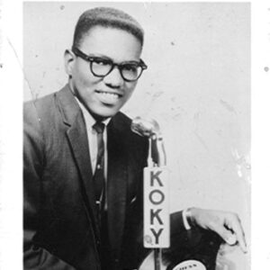 Young African-American man in suit and glasses holding a vinyl record on promotional flyer with text