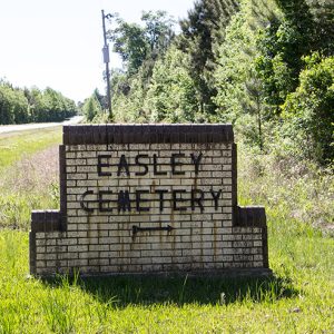 Brick "Easley Cemetery" sign on grass next to road