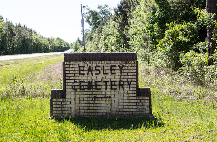 Brick "Easley Cemetery" sign on grass next to road