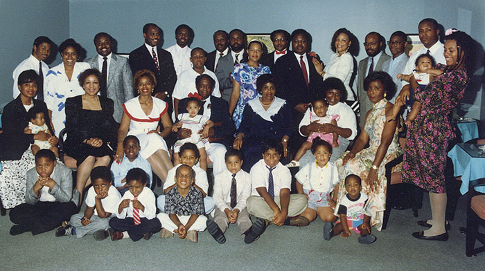 Group of dressed-up African-American men women and children sitting and standing together