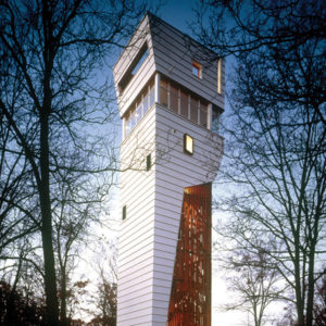House tower with white siding and exposed beams at dusk