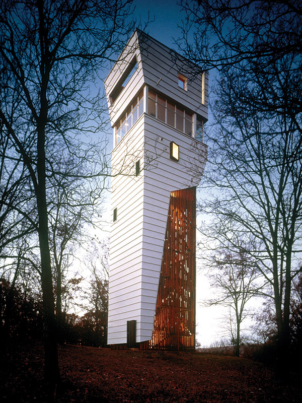 House tower with white siding and exposed beams at dusk