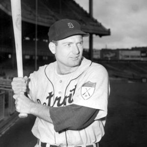 White man holding a bat in Detroit Tigers uniform with empty stadium in background