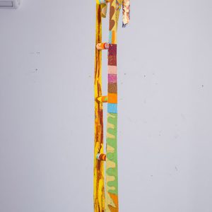 Multicolored "ladder" made of belts hanging from gallery ceiling