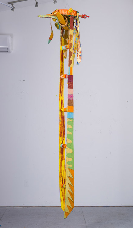 Multicolored "ladder" made of belts hanging from gallery ceiling