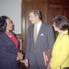 African-American woman in suit talking to white man in suit and white woman in yellow shirt