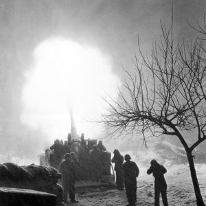 Soldiers firing artillery into the air while it snows