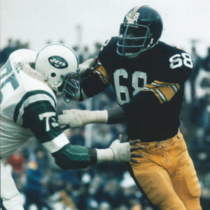 Man in New York Jets uniform tackling man in Pittsburgh Steelers uniform during football game