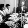 Older African American man and woman at dinner table with younger African American boys and girls