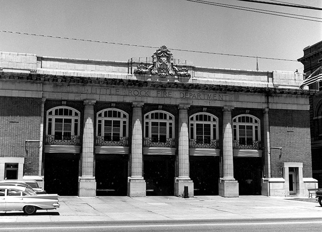 Multistory ornate fire department building with four columns and five garage bays