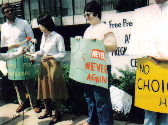 Young white protesters with signs being interviewed by local news