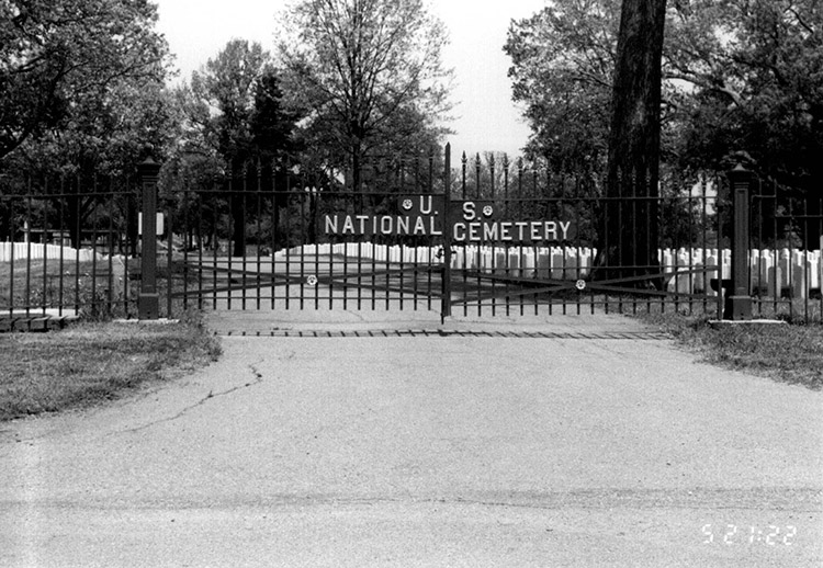 "U.S. National Cemetery" iron gates with gravestones beyond it