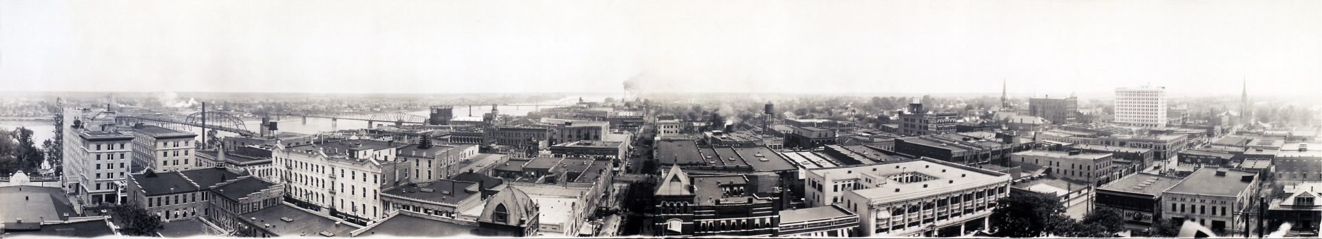 Panorama downtown Little Rock skyline with river to left three bridges and center factory smoke