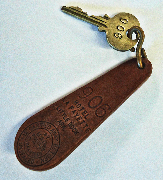 Brass key with the number 906 engraved on it and leather key fob
