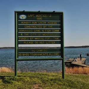 Park sign and lake with boat launching from dock