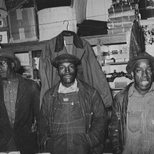 African-American men standing in front of shelves in store