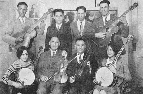 Group of white men and two women with their instruments