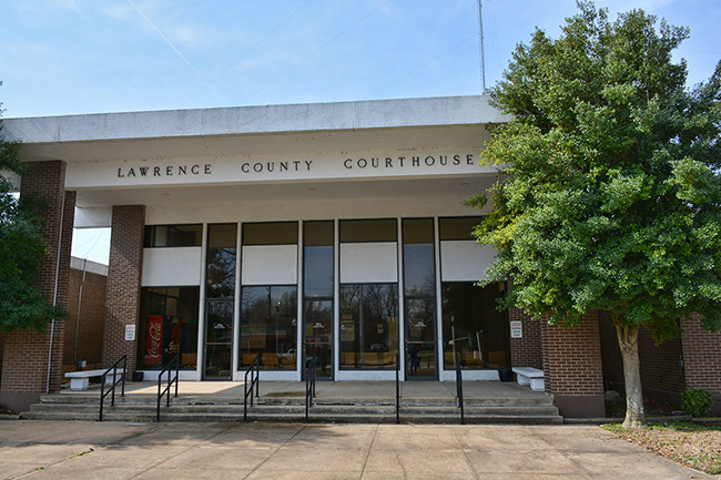 Close-up of "Lawrence County Courthouse" covered entrance with glass doors on steps with railings