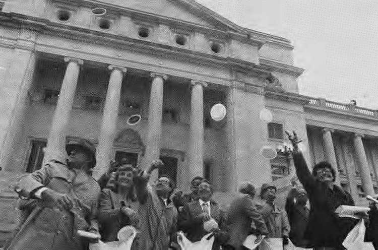 White men and women throwing "pennies" outside multistory building with four front columns and large dome
