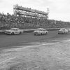 Cars racing on dirt track with crowded stands