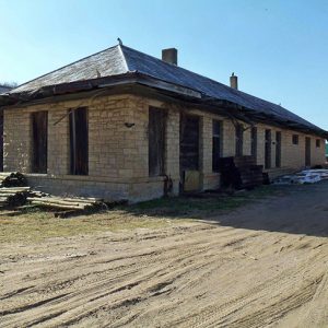 Abandoned brick train depot on dirt road