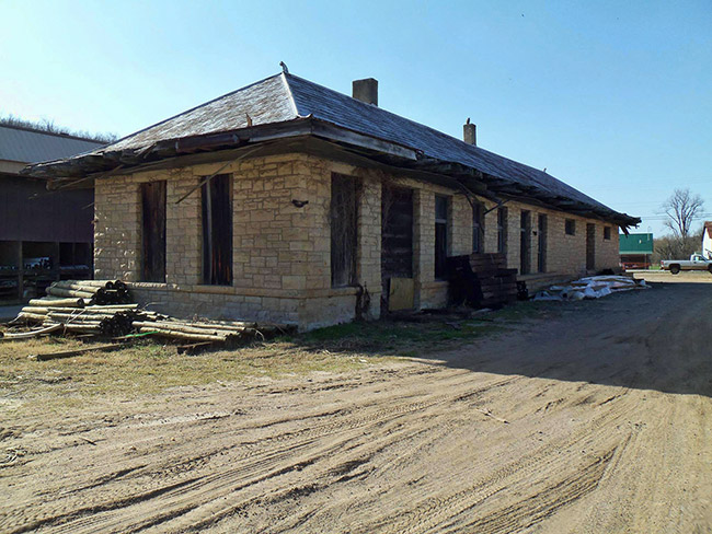 Abandoned brick train depot on dirt road