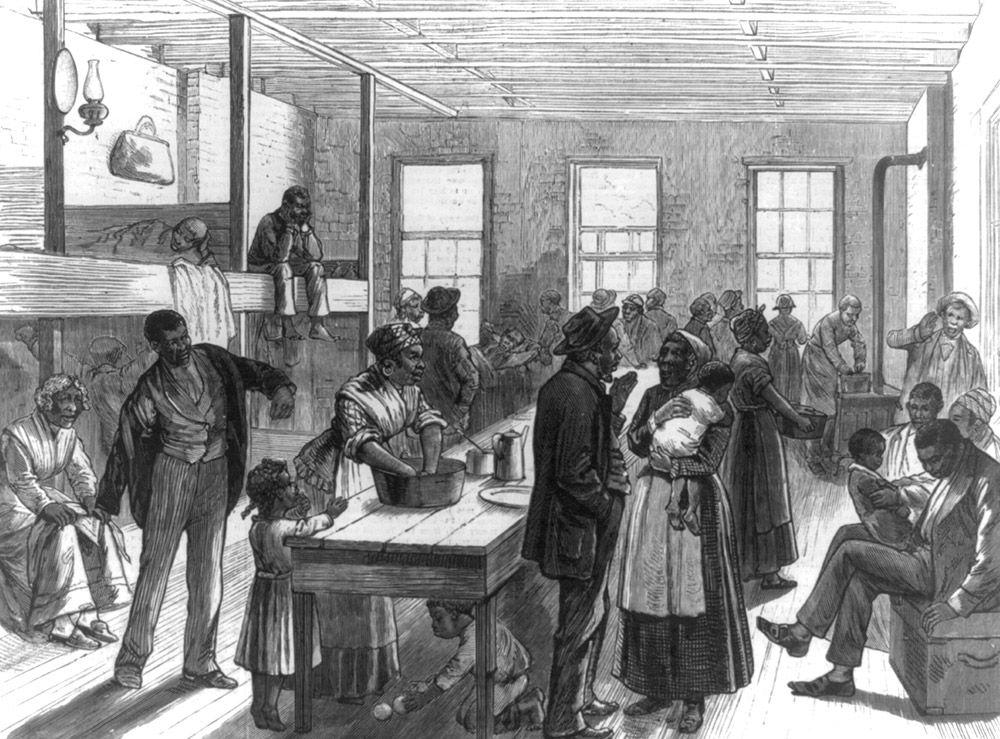 African American adults and children gathered in large room with beds and tables