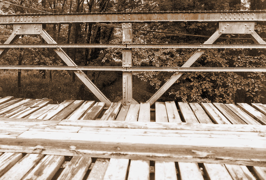 View standing on wooden platform of steel truss bridge
