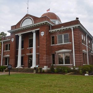 Multistory brick building with two front columns and dome