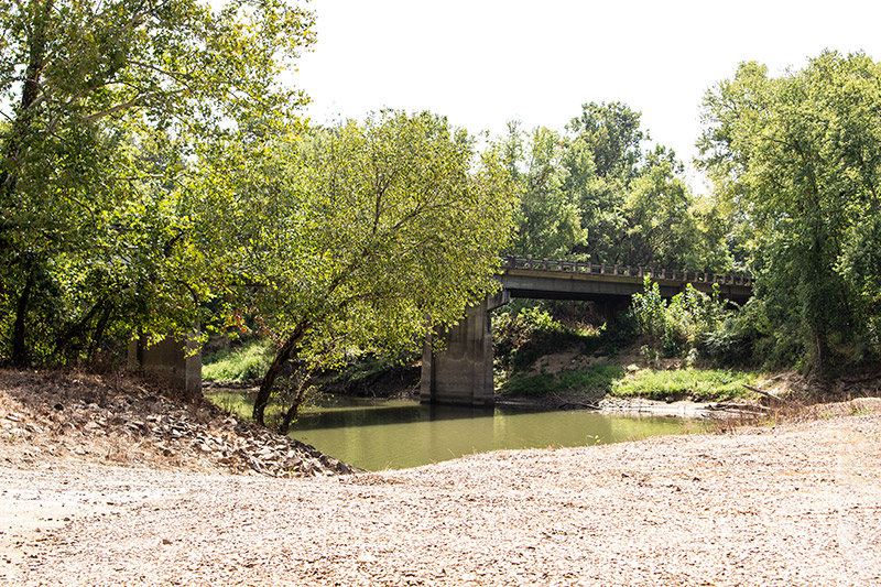 Side view of concrete bridge over river as seen from the bank