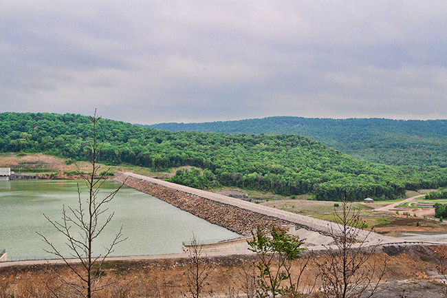 Lake dam with tree covered countryside in the background