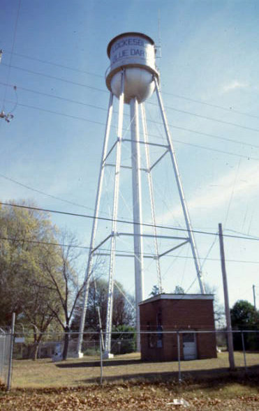 Water tower and brick building inside fence