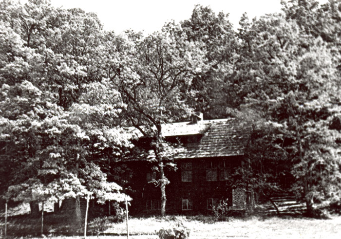 Three-story camp building surrounded by trees