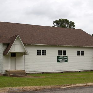 Single-story building with white siding and covered entrances on either end
