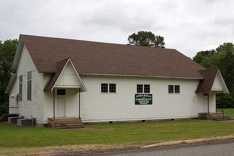 Single-story building with white siding and covered entrances on either end