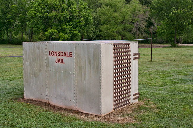 Concrete box with cage door and "Lonsdale Jail" in red written on the side