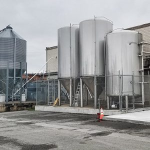 Brewery tanks and outbuildings behind brick building