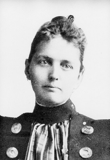 younger white woman in jacket with a high neck and large buttons