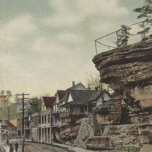Rock outcropping over residential road with multistory houses