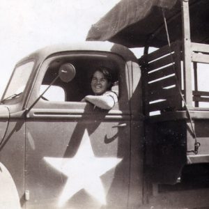 Young white woman driving military truck