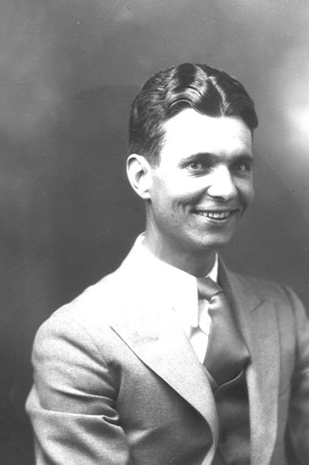 White man smiling in suit and tie