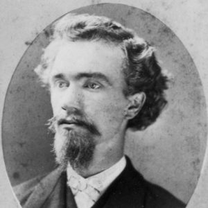 portrait  oval frame young white man wavy hair mustache beard suit small white ribbon tie