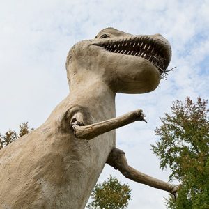 Looking up at weathered Tyrannosaurus Rex statue