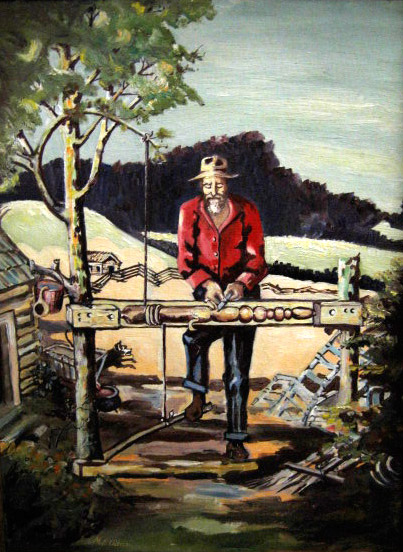Old white man in hat and red shirt using a lathe outside his cabin